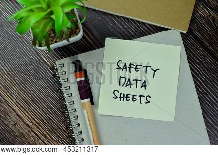 Safety Data Sheets Write On Sticky Notes Isolated On Wooden Table.