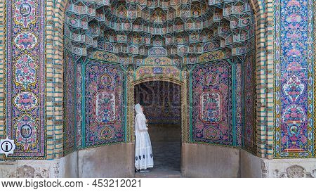Iran, Shiraz - May 2019: Nasir Al-mulk Mosque With Colorful Tiles And A Tourist Leaning At The Gate