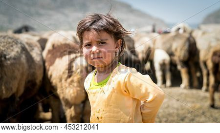Shiraz, Iran - May 2019: Portrait Of Qashqai Turkish Girl With A Group Of Goats In A Nomad Camp. Qas