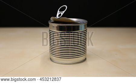 Yellow Corn Is Scattered On The Table. A Can Of Canned Corn With Juice Is Open And Stands On A Woode