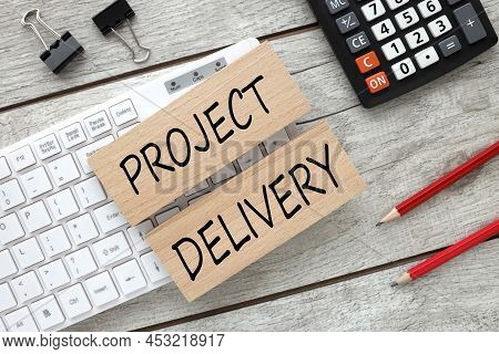Project Delivery. Text On Wooden Blocks On White Keyboard