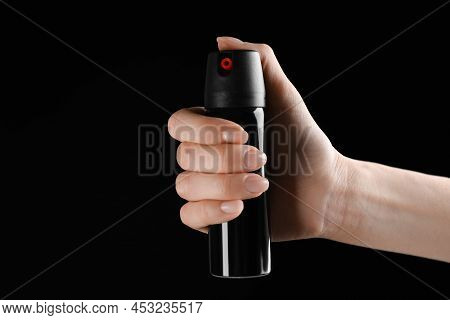 Woman Holding Pepper Spray On Black Background, Closeup. Space For Text