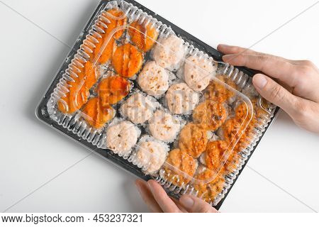 Delivery Of Japanese Traditional Sea Food, Asian Cuisine. Close-up Of Hand Holding Set Of Hot Baked 