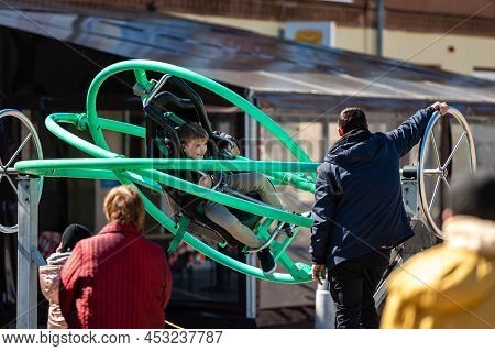 Dobele, Latvia - April 17, 2022: Kids Enjoy The Extreme Attraction Aerotrim - A Human Gyroscope With
