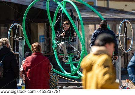 Dobele, Latvia - April 17, 2022: Kids Enjoy The Extreme Attraction Aerotrim - A Human Gyroscope With