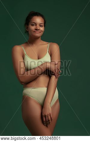 Portrait Of Young Woman Posing In Underwear Isolated Over Green Studio Background. Tenderness, Natra