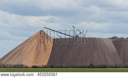 Giant Spreader Or Absetzer Machinery. A Large Dumper On A Landfill With Potash Ore. Extracting Potas