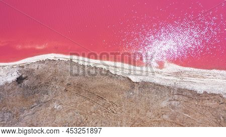 Flying Over A Pink Salt Lake. Salt Production Facilities Saline Evaporation Pond Fields In The Salty