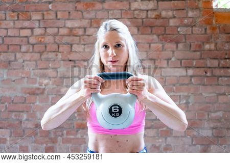 Young Muscular Woman Doing High Pull Exercise With Kettlebells On Hard Training At The Garage Gym. H