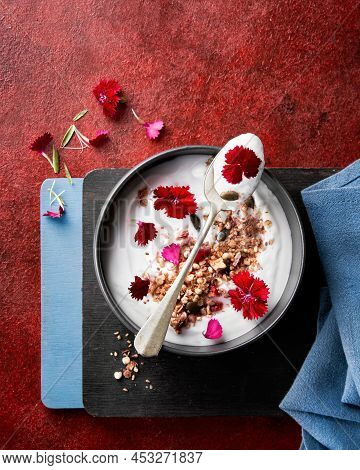 Yogurt Bowl With Homemade Baked Granola Decorated With Fresh Carnation Edible Flowers. Selective Foc