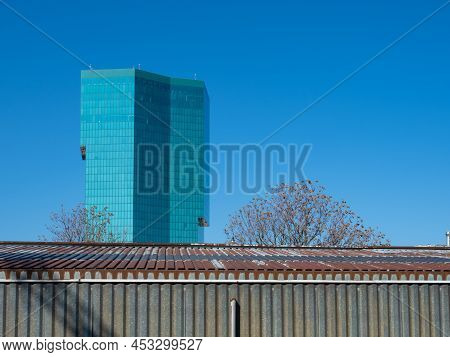 Zurich, Switzerland - March 5th 2022: The Famous Prime Tower In Front Of A Corrugated Metal Building
