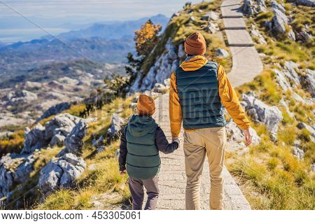 Dad And Son Travellers In Mountain Landscape At National Park Lovcen, Montenegro. Travel To Monteneg