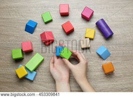 Aba Therapist With Colorful Building Blocks At Wooden Table, Top View