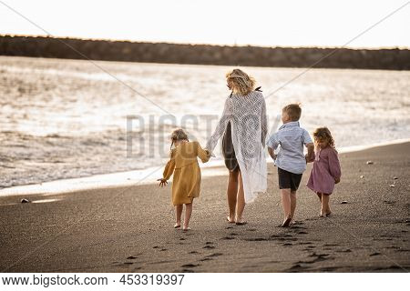 Beautiful Family Walking On The Beach. Mother With Kid Spending Time Together On Vacation. Full Leng