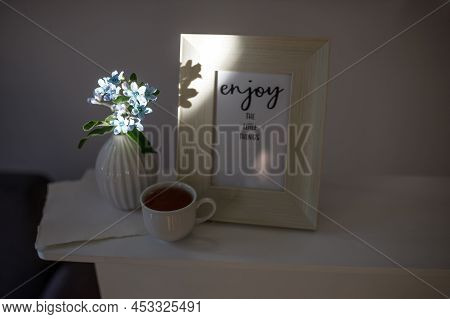 Flower Hackelia Velutina In A White Fluted Vase In The Style Of The Seventies, A Photo Frame With Th