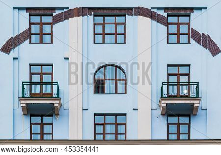 Two Balconies And Several Windows In A Row On The Facade Of The Modern Urban Apartment Building Fron