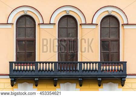 Balcony And Three Windows In A Row On The Facade Of The Urban Historic Apartment Building Front View