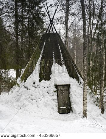 A Traditional Sami Tent (kota) , Covered By A Mossy Fabric, In A Snowy Finnish Fir Forest