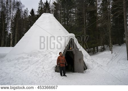 Rovaniemi, Finland - March 18th, 2022: A Sami Man In Traditional Clothes, Standing At The Door Of Hi