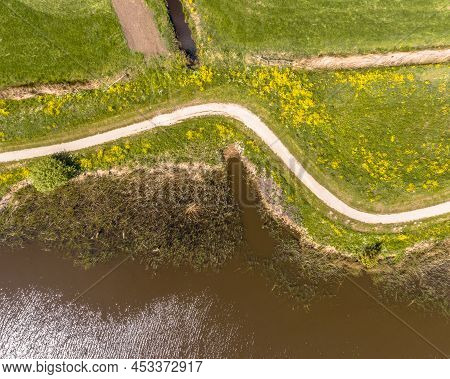 Aerial Springtime Scene Of Dutch River Near Boornzwaag. Cycling Track On Dike Meandering Throug Pold