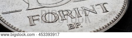 Hungarian Coin Of 10 Forints Lies On A Dark Black Surface Close-up. Money Of Hungary. News About