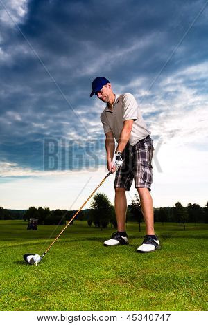 Young golf player on course doing golf swing, he presumably does exercise