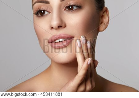 Woman With Beauty Face Touching Healthy Facial Skin Portrait. Beautiful Smiling Girl Model With Natu