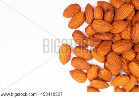 Almonds Pieces On White Background And Copy Space.