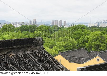 Looking Out Over The Roof Tops Of The Jinshan Temple With The City Of Zhenjiang In The Background On