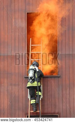 Firefighter In Action In The Fire Station With Self-contained Breathing Apparatus And Oxygen Cylinde