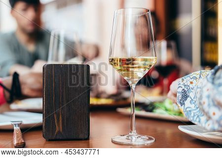 Glass Of White Wine Next To A Napkin Holder