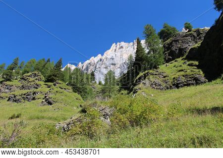 The View Of A Mountain Massif And Green Forest At Foothills In A Sunny Day.