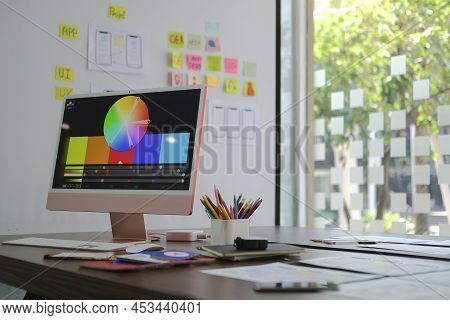 Creative Designer Workplace With Modern Computer, Paperworks And Stationery On Wooden Table.