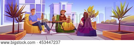 Friends Relax At Rooftop Or Home Terrace With Cityscape View. People Resting On Open Roof Top Patio 