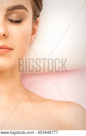 Close Up Of Half-face Of A Serene Young Woman Is Lying With Closed Eyes Top View, Copy Space
