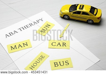 Taxi Car Model And Paper Sheet With Phrase Aba Therapy On White Wooden Table