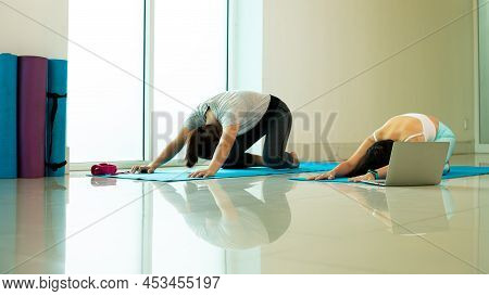 Two Asian Young Female Adult Practice Yoga Pose Extended Puppy Or Uttana Shishosana On Blue Mat In G