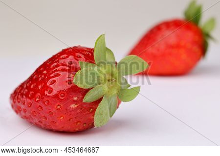 Macroshot Of Fresh Red Strawberries, One In The Foreground And One In The Back