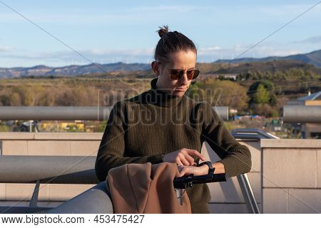 Close Up Portrait Of Man Whearing A Bun Hairstyle And Sunglasses Using Smart Watch On Wrist With Tow