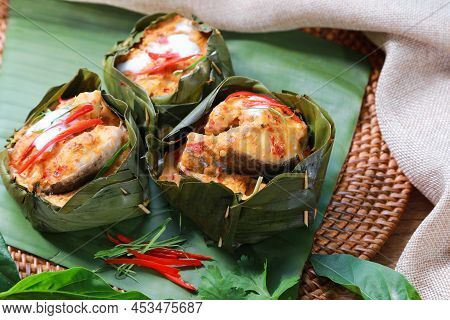 Traditional Steamed Snakehead Fish With Curry Paste And Tahitian Noni Leaf Inside. Red Chili And Kaf