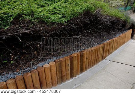 Park Threshing Beige Gravel Roads In The Sloping Terrain Have A Wooden Palisade Retaining Wall Above