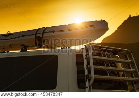 Car Van With Canoe On Top Roof Against Sunset Sky. Active Lifestyle, Vanlife Concept.