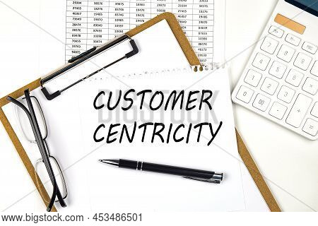 Text Customer Centricity On White Paper On Clipboard With Chart And Calculator
