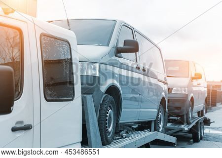 White Small Cargo Truck Car Carrier Loaded With Two Yellow Van Minibus On Flatbed Platform And Semi 