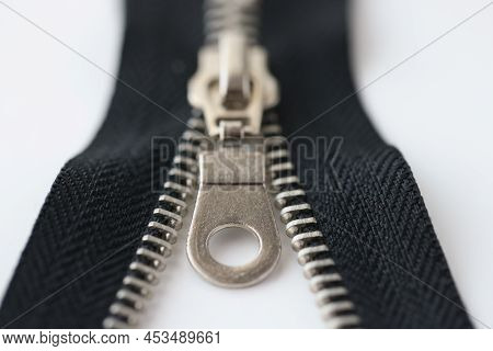 Closeup Macro Shot Of Open Black Brass Zipper Isolated On White Background. Metal Zipper Is Connecte