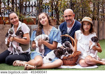 Young family outdoors with their new born puppies in a sunny day