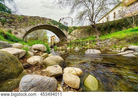 Medieval Stone Bridge That Crosses Over The River Of Hervas, Caceres.