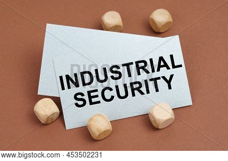 The Concept Of Industrial Safety. On A Brown Surface, Wooden Cubes And A Business Card With The Insc