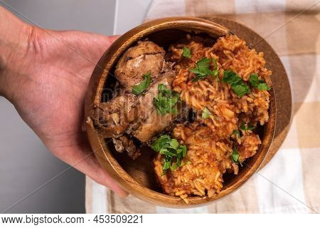 Bowl Of East African Jollof Rice Garnished With Pieces Of Roasted Chicken
