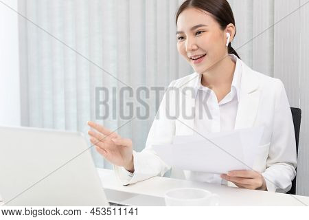 Young Asian women are talking friends and manager through video chats and greeting them with cheerfu